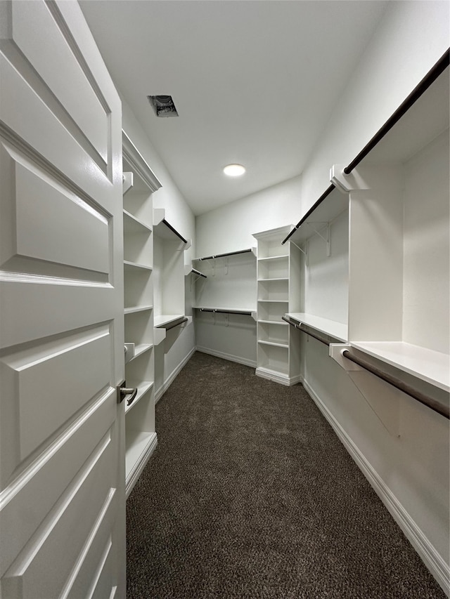 spacious closet with dark carpet