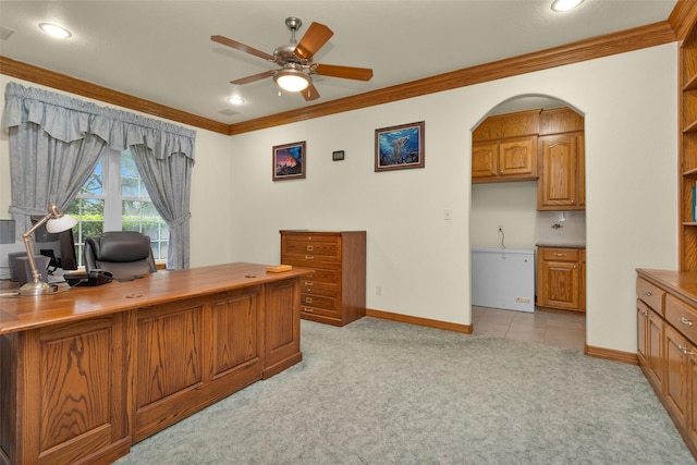 home office featuring baseboards, arched walkways, a ceiling fan, light colored carpet, and crown molding