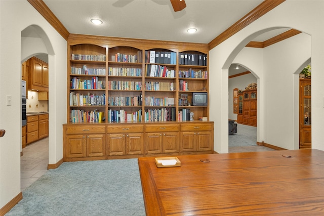 interior space with crown molding, light carpet, ceiling fan, and built in shelves