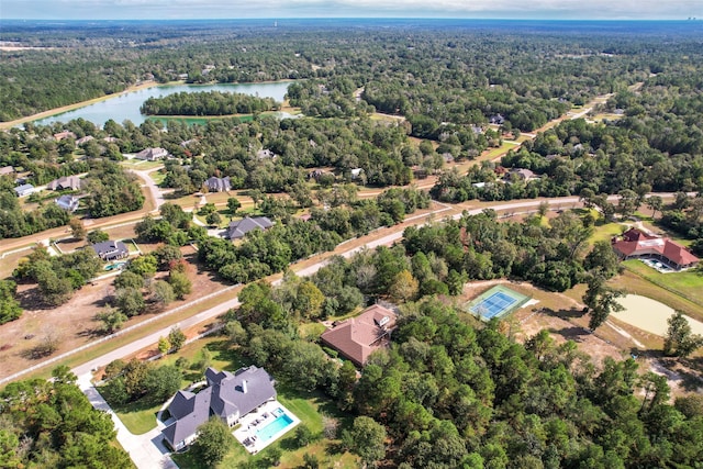 birds eye view of property featuring a forest view and a water view