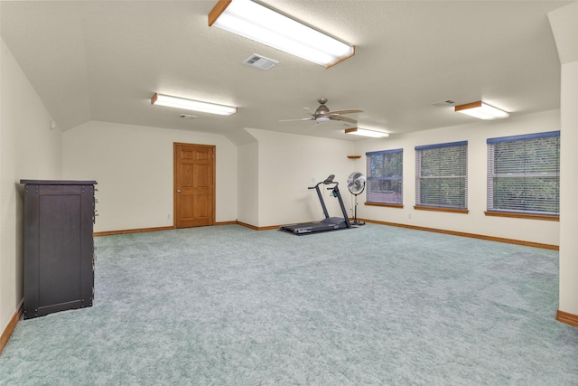 exercise room with carpet floors, a ceiling fan, visible vents, vaulted ceiling, and baseboards