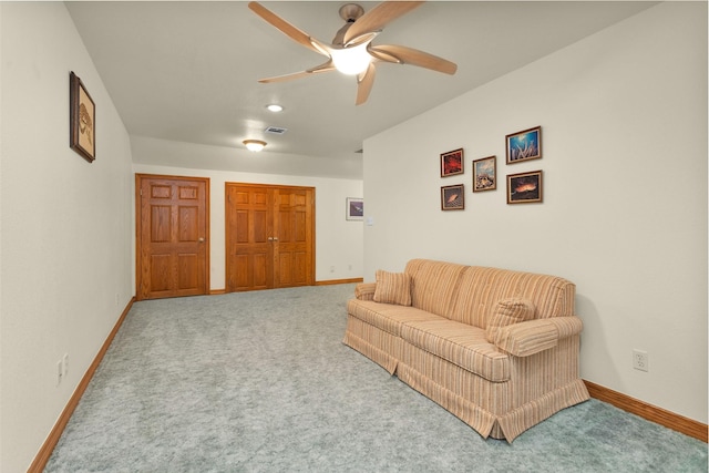 carpeted living room featuring baseboards, visible vents, and ceiling fan