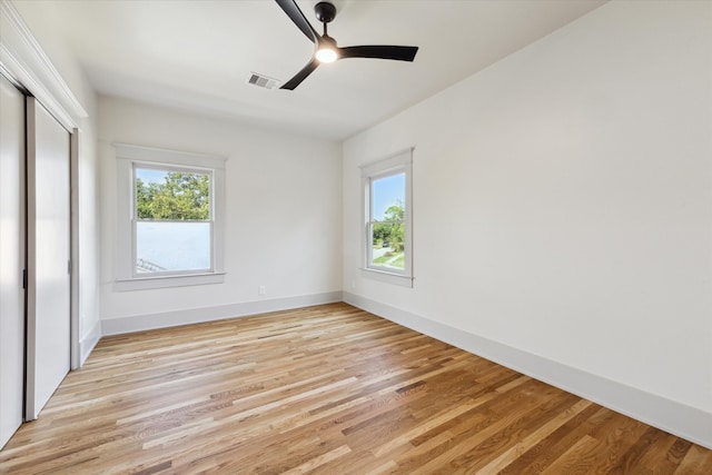 unfurnished bedroom featuring light hardwood / wood-style floors, ceiling fan, and a closet