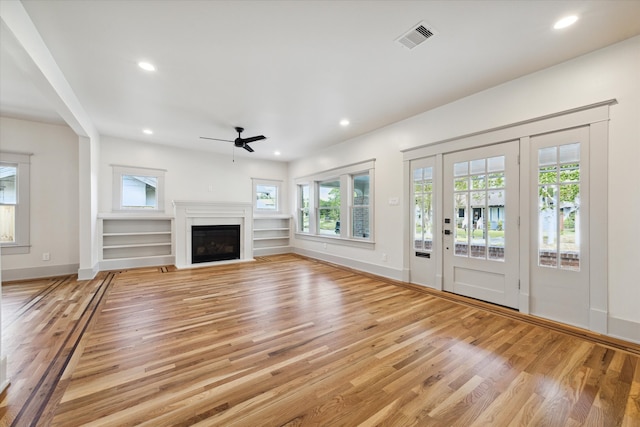 unfurnished living room featuring light wood-type flooring and ceiling fan