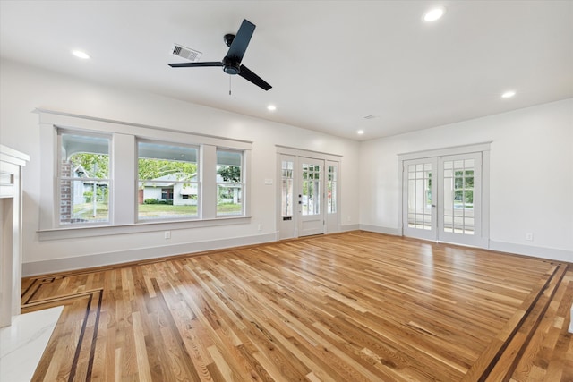 unfurnished living room with ceiling fan, plenty of natural light, light hardwood / wood-style flooring, and french doors