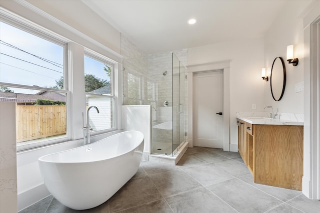 bathroom with tile patterned flooring, vanity, and separate shower and tub