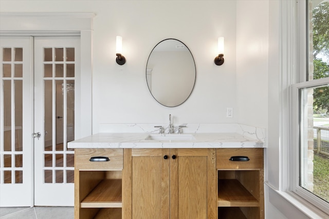 bathroom with french doors, a wealth of natural light, vanity, and tile patterned floors