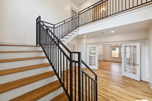 stairs featuring a high ceiling and hardwood / wood-style flooring