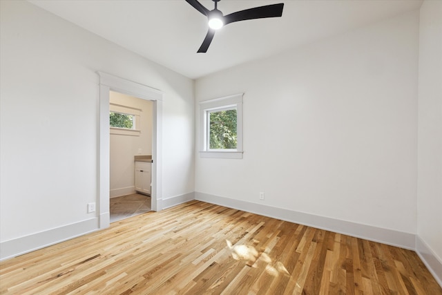 unfurnished bedroom with ensuite bathroom, light wood-type flooring, and ceiling fan