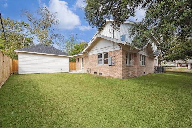 rear view of house featuring central AC and a yard