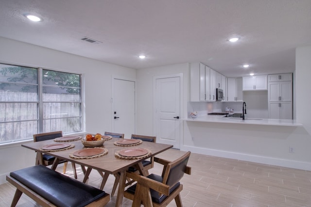 dining room featuring light wood-type flooring and sink