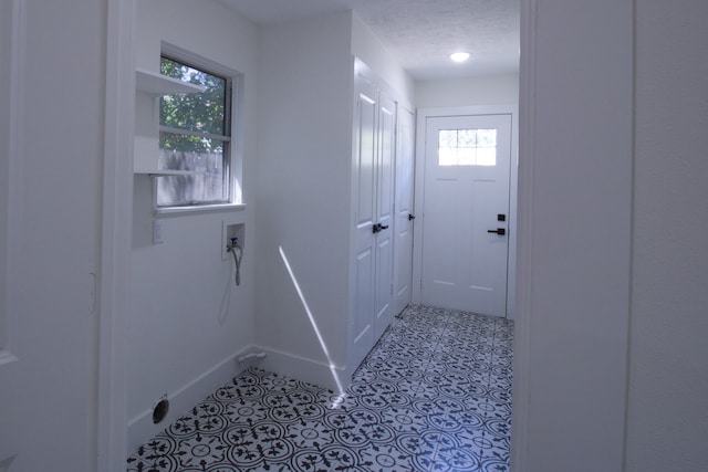 doorway to outside with a textured ceiling