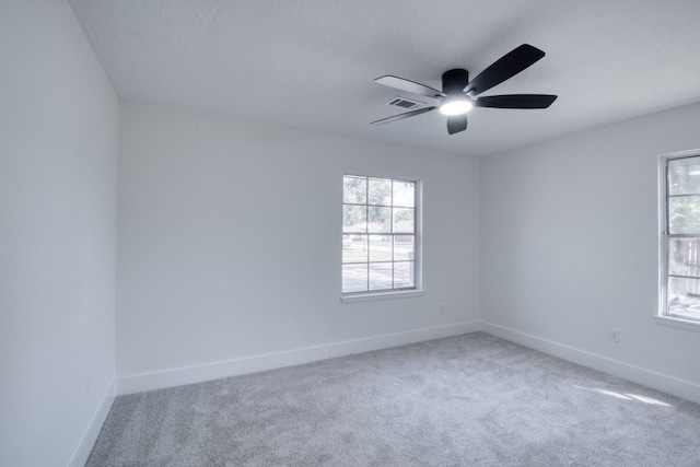 empty room with carpet flooring, a healthy amount of sunlight, and ceiling fan