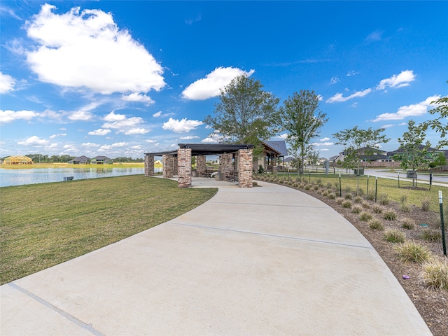 view of property's community with a water view and a yard