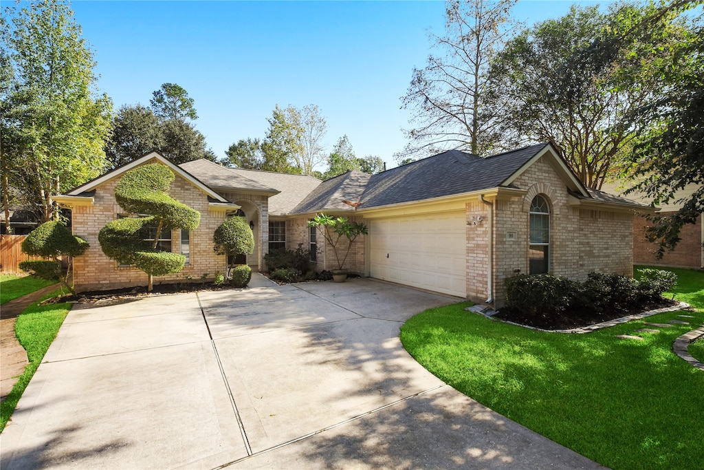 ranch-style home featuring a front lawn and a garage