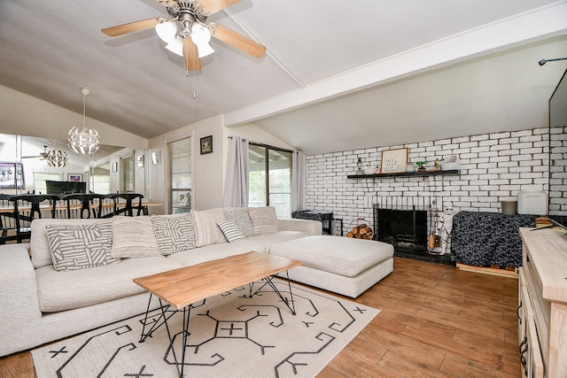 living room featuring hardwood / wood-style flooring, brick wall, ceiling fan, vaulted ceiling with beams, and a brick fireplace