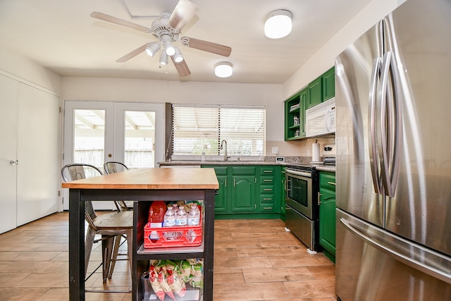 kitchen with french doors, stainless steel appliances, light wood-type flooring, green cabinetry, and ceiling fan