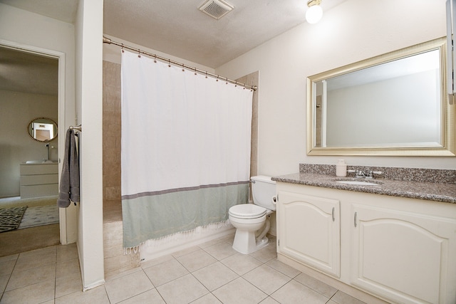 full bathroom with toilet, vanity, a textured ceiling, and tile patterned flooring