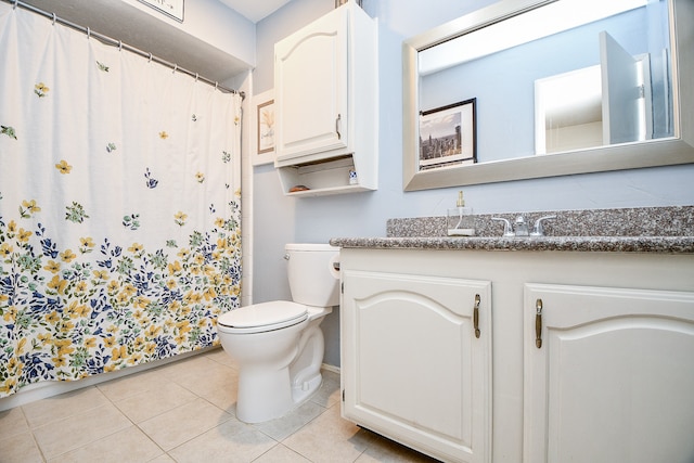 bathroom featuring toilet, vanity, and tile patterned flooring