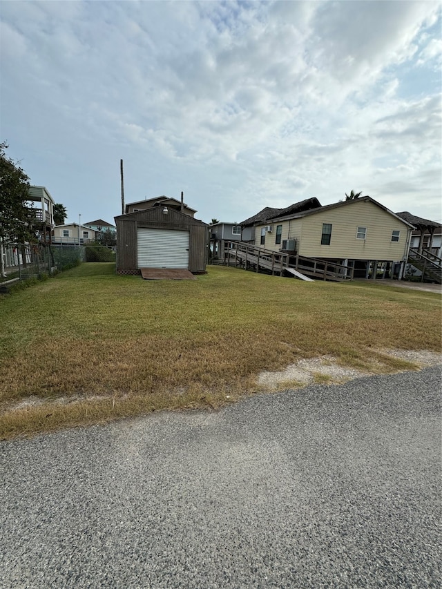 exterior space featuring a garage, an outdoor structure, and a lawn