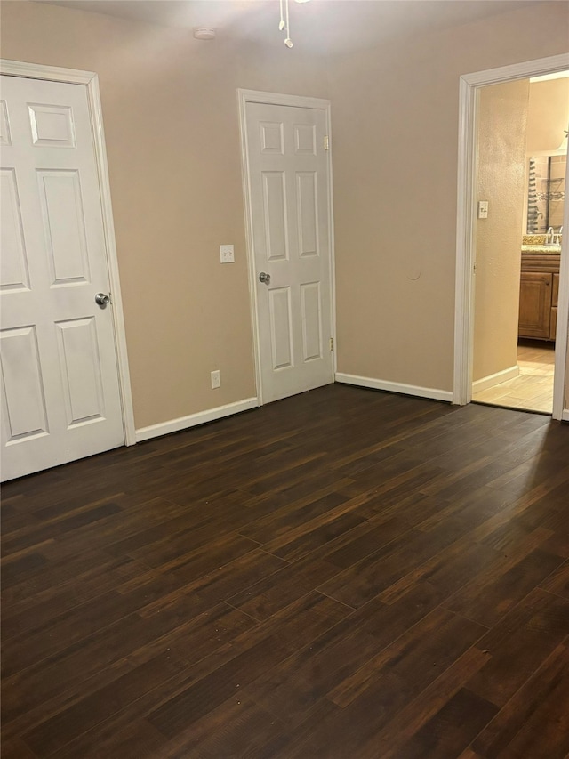 empty room with dark wood-type flooring and sink