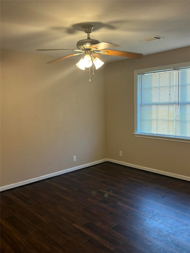 empty room with ceiling fan and dark hardwood / wood-style floors