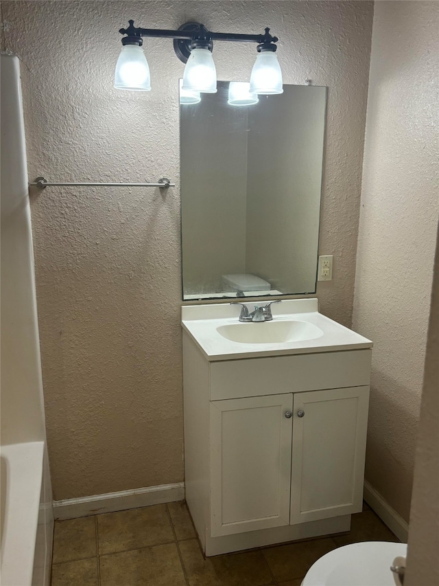 bathroom with a tub, tile patterned flooring, vanity, and toilet