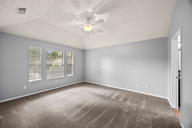 carpeted empty room featuring a textured ceiling, ceiling fan, and vaulted ceiling