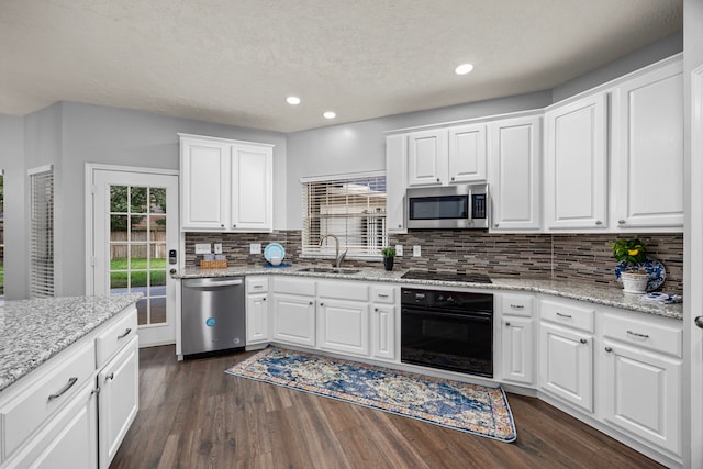 kitchen with black appliances, white cabinetry, and sink