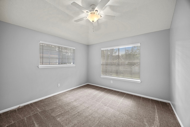 carpeted spare room with a textured ceiling and ceiling fan