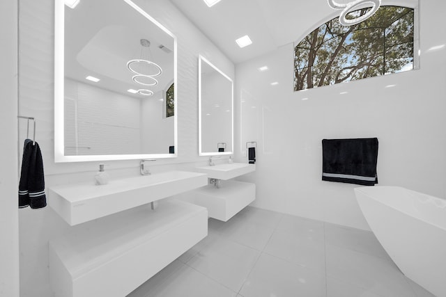 bathroom with a bathtub, vanity, tile patterned flooring, and a notable chandelier