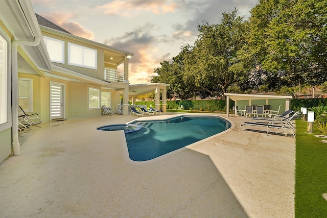 pool at dusk featuring a patio area