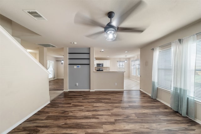 unfurnished living room featuring dark hardwood / wood-style floors and ceiling fan