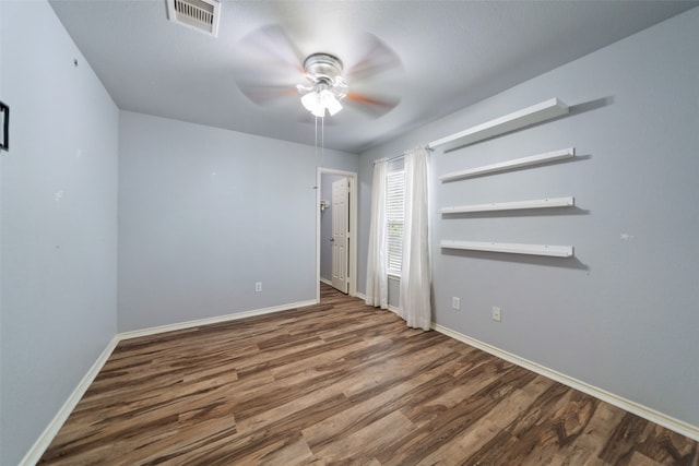 empty room featuring dark hardwood / wood-style flooring and ceiling fan