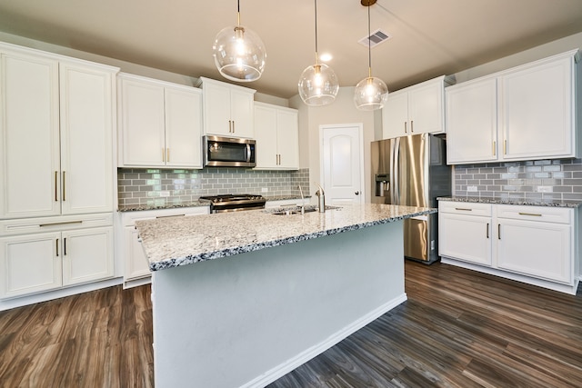 kitchen featuring stainless steel appliances, hanging light fixtures, white cabinets, and tasteful backsplash