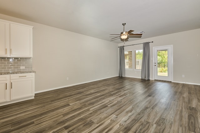 unfurnished living room featuring ceiling fan and dark hardwood / wood-style floors