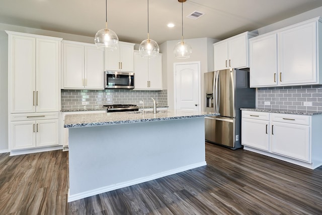 9291 Inland Leather Ln, Conroe, TX 77385 - kitchen featuring appliances with stainless steel finishes, dark wood-style floors, decorative backsplash, white cabinets, and recessed lighting