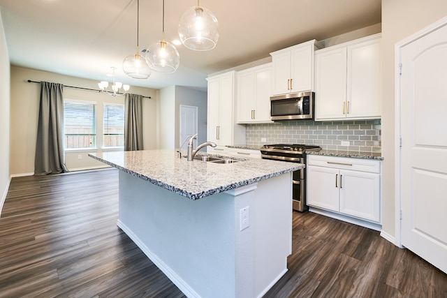 kitchen with pendant lighting, a kitchen island with sink, dark hardwood / wood-style floors, white cabinetry, and appliances with stainless steel finishes