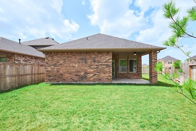 back of house with ceiling fan, a lawn, and a patio area