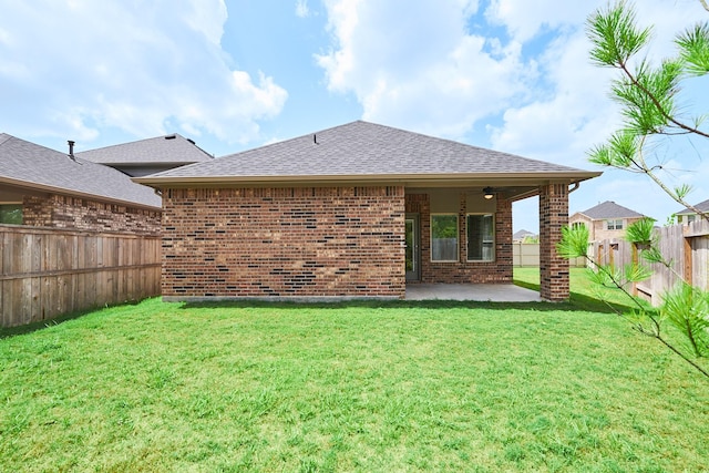 9291 Inland Leather Ln, Conroe, TX 77385 - back of property featuring a shingled roof, a patio, and brick siding