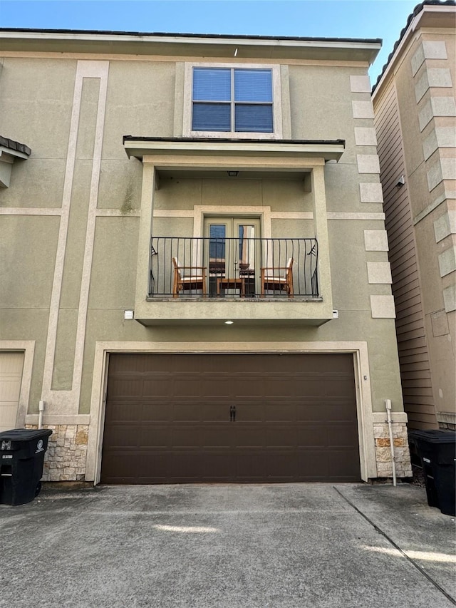 townhome / multi-family property featuring a balcony and a garage