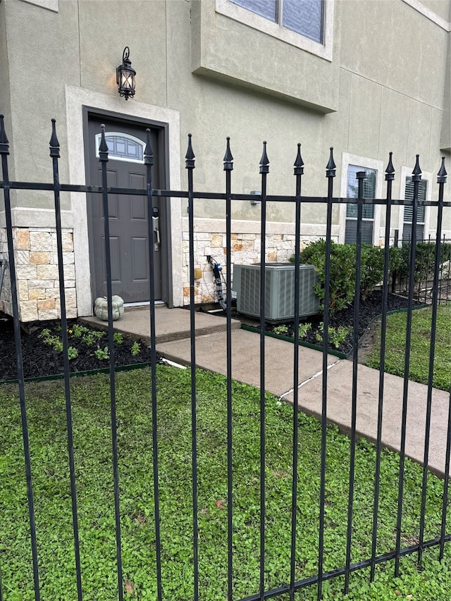 doorway to property with central AC unit and a yard