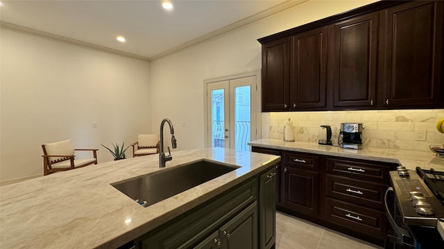 kitchen with sink, tasteful backsplash, ornamental molding, stainless steel stove, and light stone countertops