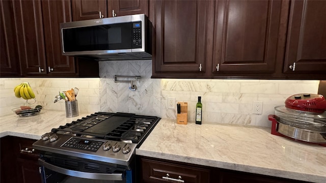 kitchen featuring dark brown cabinetry, backsplash, and appliances with stainless steel finishes