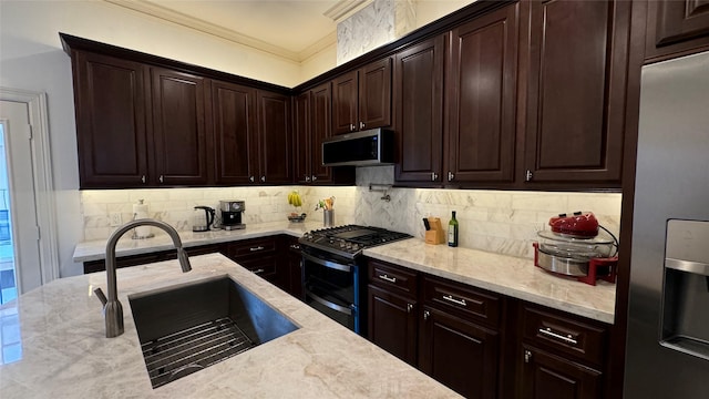 kitchen with sink, backsplash, light stone counters, stainless steel appliances, and crown molding