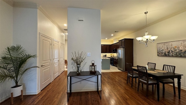 dining area with an inviting chandelier, ornamental molding, and dark hardwood / wood-style floors