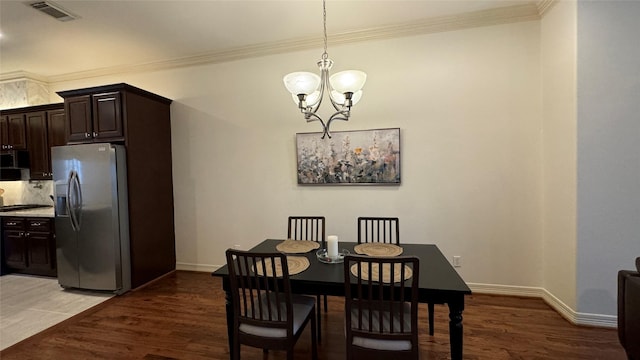 dining room featuring a notable chandelier, ornamental molding, and dark hardwood / wood-style floors