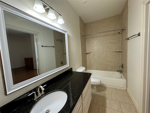 full bathroom featuring tiled shower / bath combo, vanity, tile patterned floors, and toilet