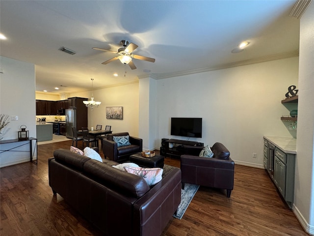 living room with dark hardwood / wood-style flooring, ceiling fan with notable chandelier, and crown molding