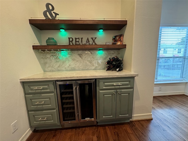 bar featuring dark wood-type flooring, gray cabinetry, wine cooler, and backsplash